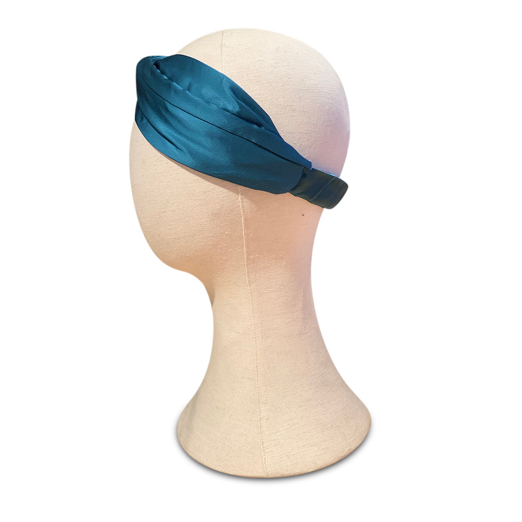 Turban headband made from teal silk viscose on mannequin head